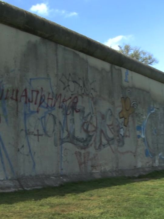 [Translate to English:] Ein Stück Berliner Mauer mit Graffiti
